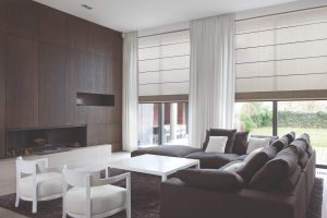 Modern living room with dark sofa, fireplace, and large windows.