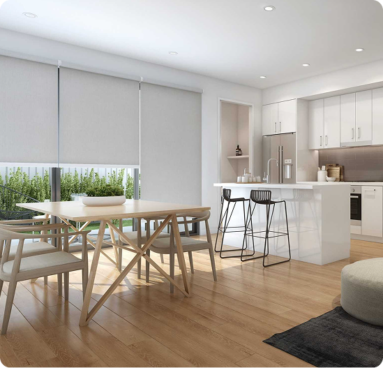 Modern kitchen and dining area with light wood flooring, white cabinetry, island with barstools, dining table, large windows with blinds, and minimalistic decor.