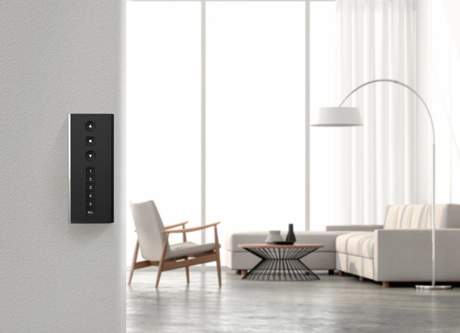 Smart control panel on wall in modern living room with sofa.