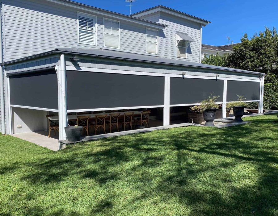 Two-story house with patio, drop-down shades, and backyard.